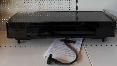 une photo d'un téléviseur posé sur une étagère, avec une télécommande