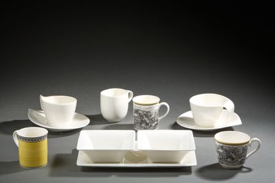 several cups and saucers are arranged on a table with a black background