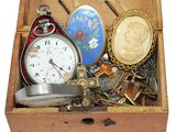 une boîte en bois contenant divers objets, dont une montre de poche