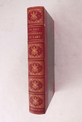 un vieux livre rouge posé sur une surface blanche