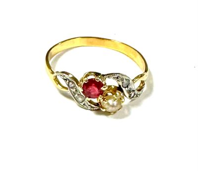 a close up of a gold ring with a red stone