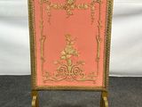 un chevalet ancien peint en doré et rose, orné d'un motif floral
