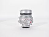 a close up of a silver camera lens on a white surface