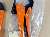 two orange pliers sitting on top of a plastic bag