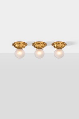 a pair of gold earrings with diamonds on a white surface