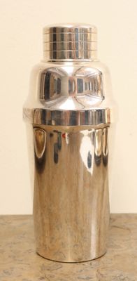 a silver container sitting on a table with a white wall in the background