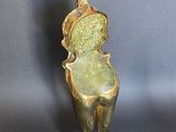 bronze sculpture of a bird on a pedestal on a gray background