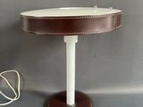 lampe de table en cuir marron avec un pied blanc et un cordon blanc