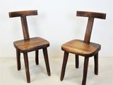 two wooden chairs sitting next to each other on a white floor