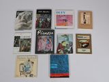 many books on a white surface that are on display