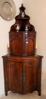 une armoire d'angle sur laquelle est posée une théière