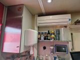 une petite cuisine équipée d'un réfrigérateur, d'un micro-ondes et d'autres appareils électroménagers