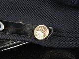 a close up of a black hat with a gold button