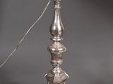 an antique silver plated lamp with a white shade on top of it