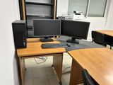 a desk with two computer monitors and a keyboard on it