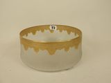 a glass bowl with a gold rim on a white surface