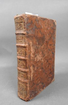 an old book sitting on top of a table next to a gray background