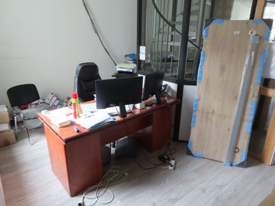 un bureau sur lequel se trouve un ordinateur, au milieu d'une pièce
