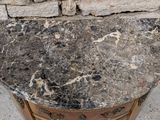 a marble top on a wooden stand in front of a brick wall