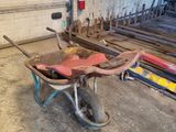 une brouette dans un garage, avec un extincteur en arrière-plan