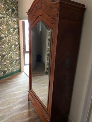 une armoire en bois surmontée d'un miroir