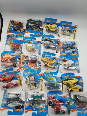 il y a plein de petites voitures Hot Wheels sur la table