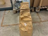 un sac en papier brun posé par terre à côté d'une pile de cartons