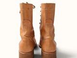 pair of brown leather boots on a white surface with a white background