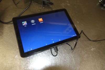 a tablet that is connected to a charger on the table