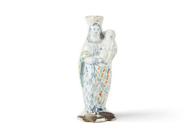 un vase blanc et bleu représentant une femme tenant un enfant dans ses bras