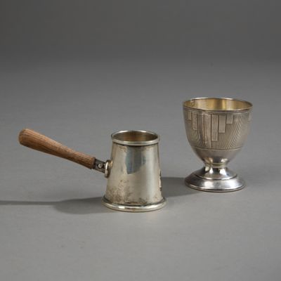 une paire de coupes en argent et un manche en bois sur un fond gris