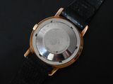 a close up of a watch on a black surface