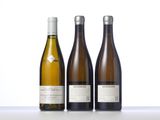 three bottles of wine are lined up on a table
