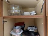 a kitchen cabinet with dishes and pans in it