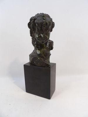 statue d'une femme avec une fleur dans les cheveux, posée sur un socle noir
