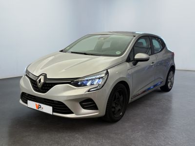 La voiture argentée est garée dans une grande pièce au sol noir.