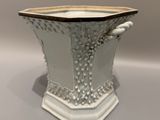 un vase blanc bordé de noir posé sur une table