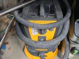un aspirateur jaune et noir posé dans un garage
