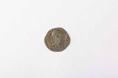 une vieille pièce de monnaie posée sur une surface blanche, sur fond blanc