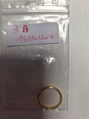 une bague en or dans un sachet en plastique sur lequel est collée une étiquette
