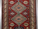 a red and blue rug with a diamond design on it