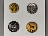 trois pièces d'or et d'argent posées sur un morceau de papier