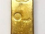 a close up of a gold bar on a white surface