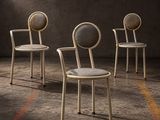 trois chaises dans une pièce où la lumière pénètre par la fenêtre