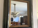 a mirror hanging on the wall above a fireplace