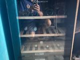 a man taking a picture of himself in a wine cooler