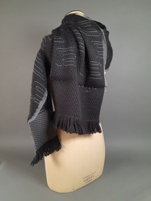 écharpe noire et grise sur une tête de mannequin, sur une tête de mannequin