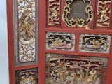 a red screen with gold and silver designs on it