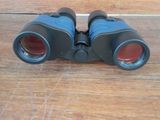 an image of a pair of binoculars sitting on a wooden floor