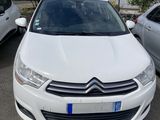 une voiture blanche garée dans un parking à côté d'autres voitures